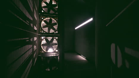 dark industrial hallway with fans and fluorescent light