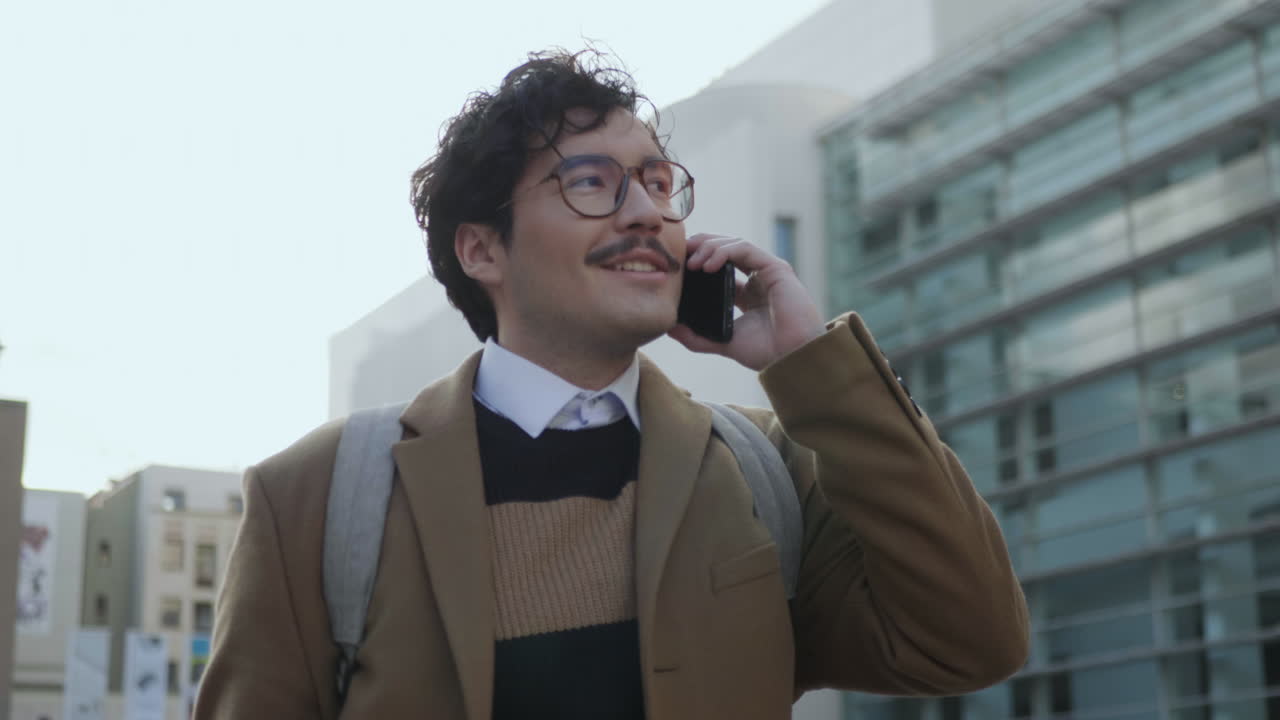 길거리에서 스마트폰으로 이야기하는 사업가. 전화로 걸어다니는 전문가