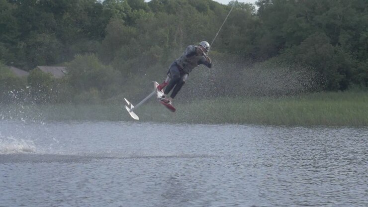 Atleta di sport acquatici estremi esegue un enorme flip, skyski o airchair