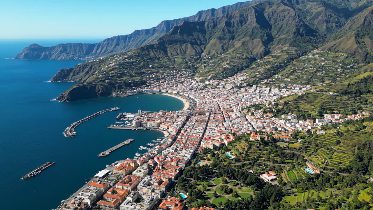 Aerial view of a coastal city surrounded by mountains