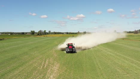 tractor agrícola esparciendo polvo blanco muy bajo primer plano frontal