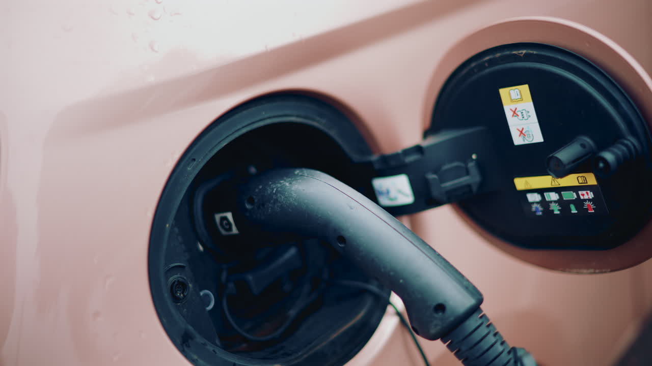 Close up of an electric car charging port with cable plugged in