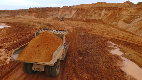 mining truck transporting sand at sand quarry. aerial view of mining machinery