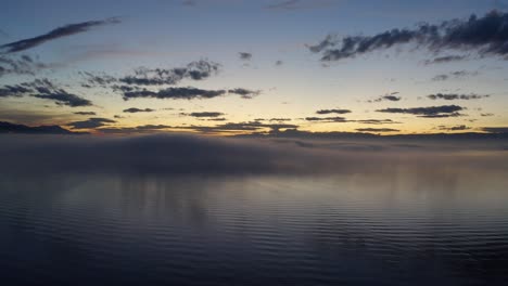 Tiefflug-über-Dem-Genfersee-Mit-Nebelflecken,-Die-Sich-Bei-Sonnenuntergang-Im-Wasser-Spiegeln-Waadt---Schweiz