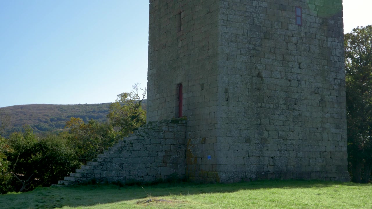 Paredes de pedra da Torre de A Forxa encontram gramado verde em Porqueira, Ourense, Galiza, Espanha