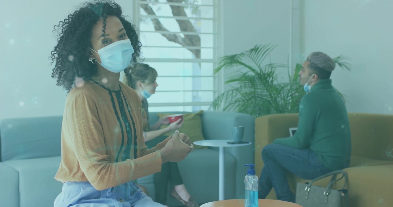 Animation of data processing over businesswomen wearing face masks
