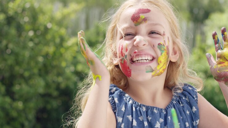Famiglia felice con bambina che dipinge in giardino
