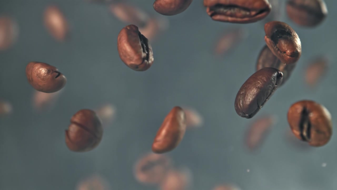 Fagioli di caffè arrostiti che cadono al rallentatore