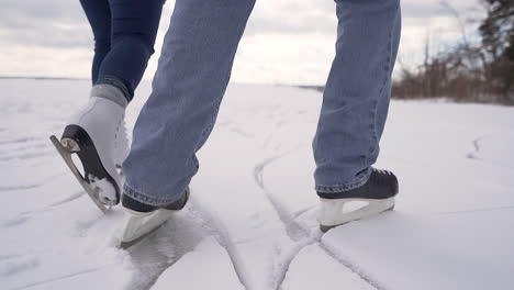 couple ice skates on snowy lake