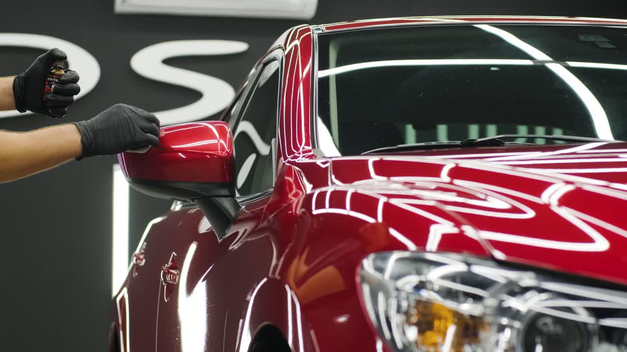 Car service worker applying nano coating on a car detail.