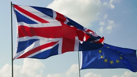bandera británica y bandera de la unión europea en el cielo azul