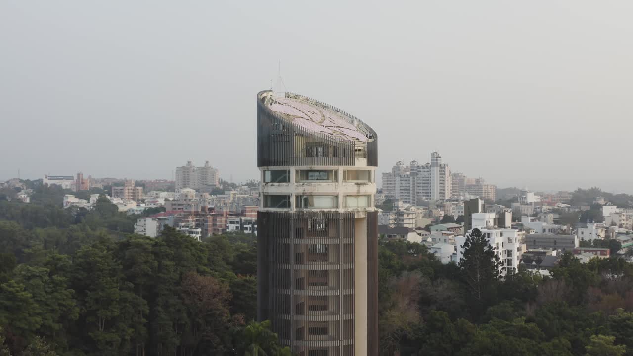 Video aereo con drone della Torre Sun-Shooting, il punto di riferimento della città di Chiayi, Taiwan, con una gigantesca Bauhinia in cima alla torre, circondata da alberi e natura con vista sulla città