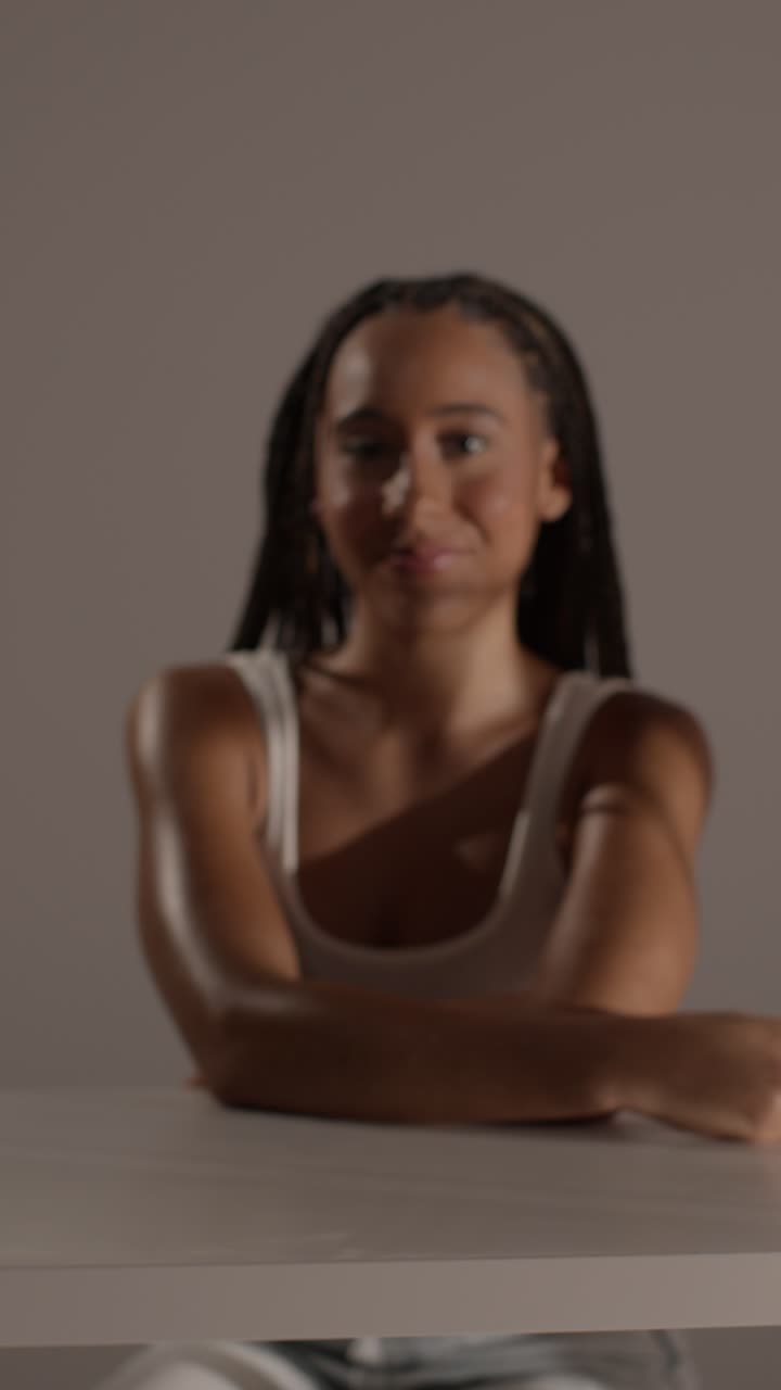 fotografía de belleza de estudio de una mujer joven con el cabello trenzado largo sentada en la mesa 6