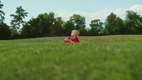 Cheerful-child-holding-ball-in-hands-outdoors