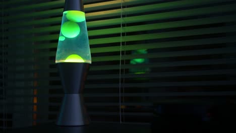 lapso de tiempo de la lámpara de lava verde en una habitación oscura-oficina cerca de una ventana