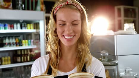 Portrait-of-smiling-waitress-holding-cup-of-coffee-on-serving-tray