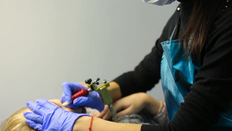 attractive lady getting facial care and eyebrow tattoo