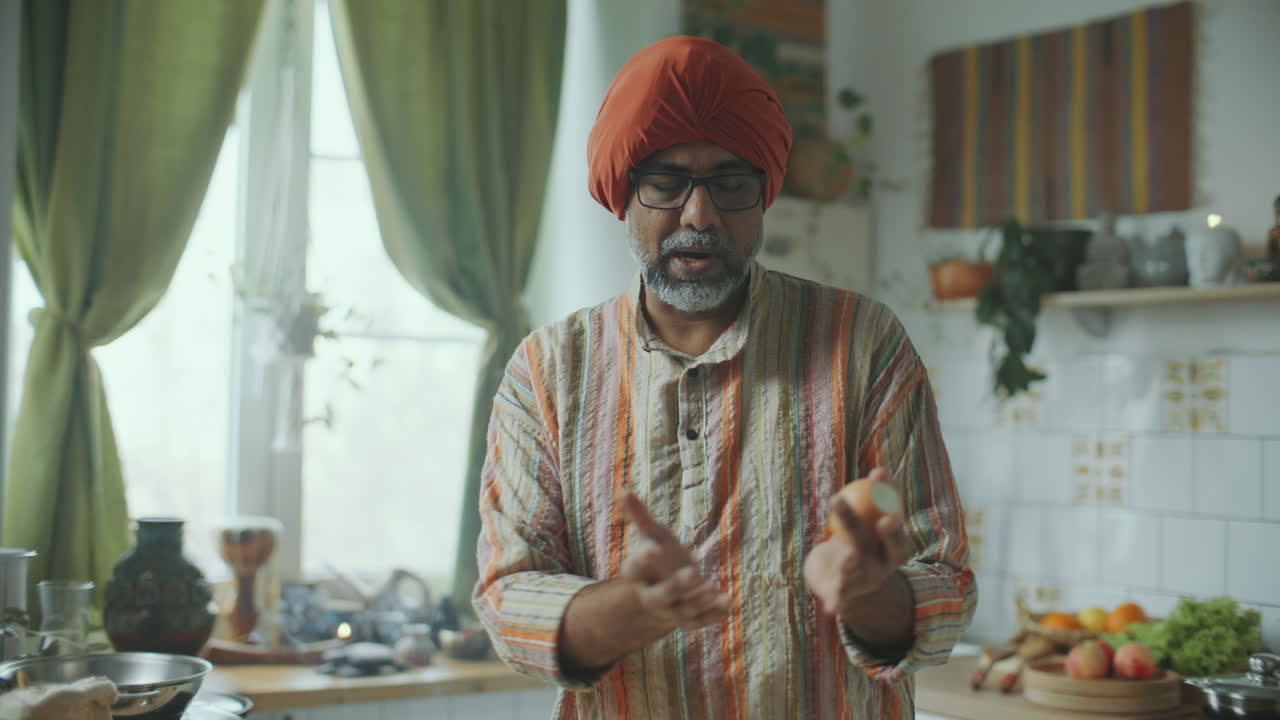 blogger de comida indio pelando cebolla y explicando la receta para el vlog culinario