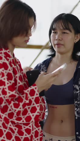 two women talking and holding phones