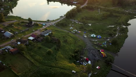 aerial view of a village festival by a lake at sunset