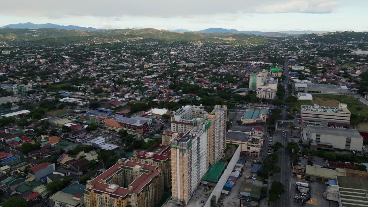 Orbiting aerial view of apartment building under construction at Marikina cityscape during daytime - NCR, Luzon, Philippines