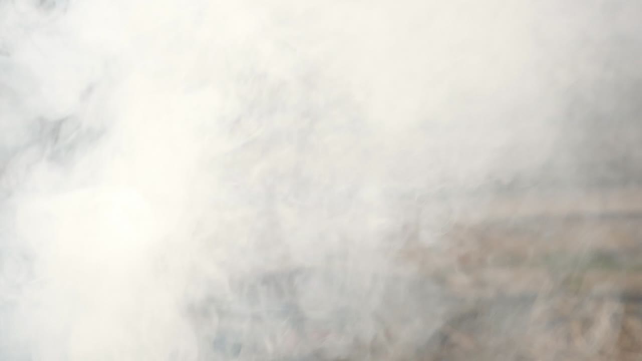 뒤에 슬레이트 울타리와 함께 야외에서 짙은 연기가 울려 퍼집니다.