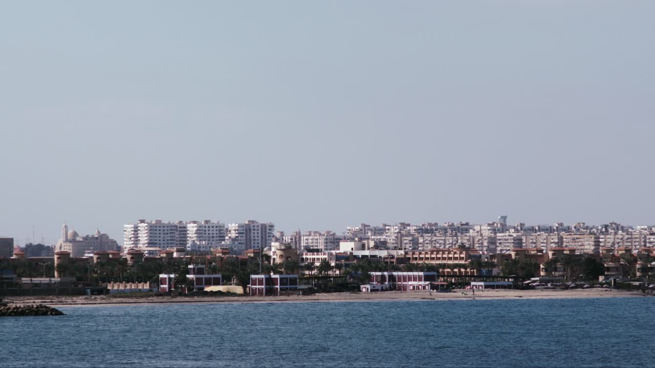 entrada del canal de suez con los edificios del puerto dicho en el fondo visto desde un buque