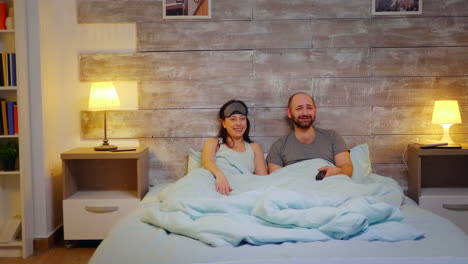 se ve una pareja en pijama riendo.