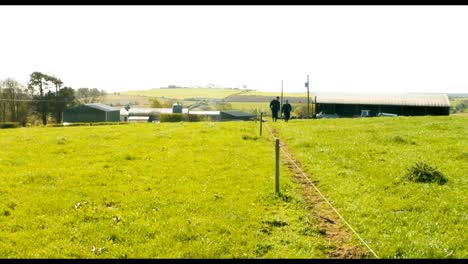 dos ganaderos caminando por el campo