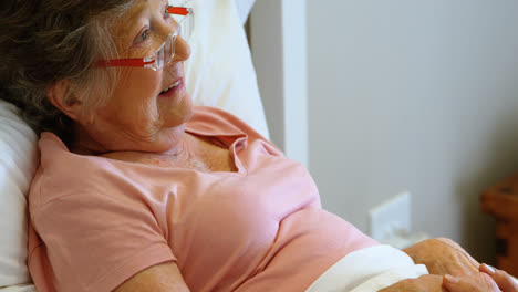 mujer mayor acostada en la cama en casa 4k
