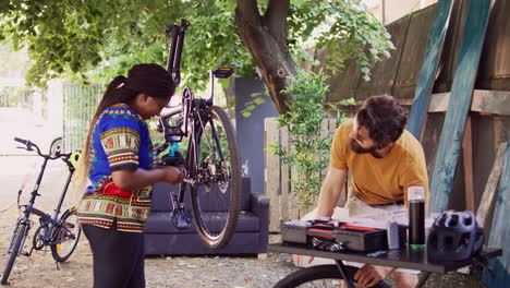 couple using equipment to fix bicycle