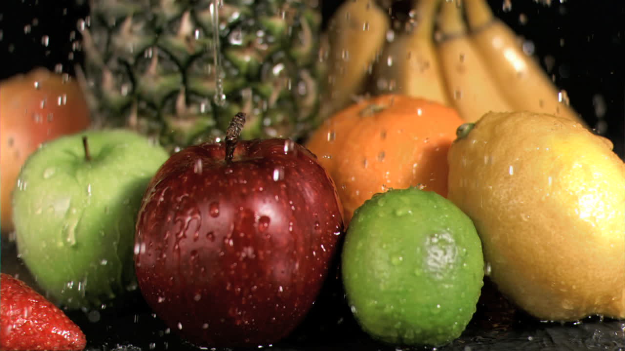 agua lloviendo sobre las frutas en súper cámara lenta