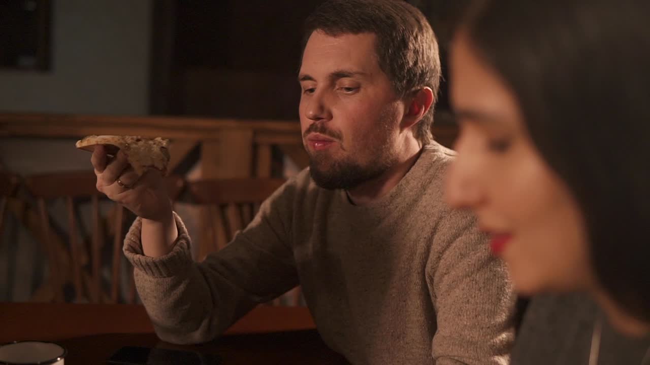 Casal comendo pizza em casa