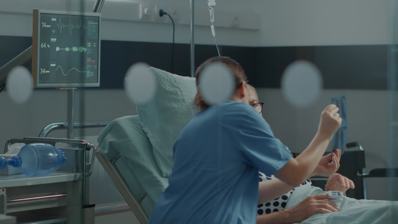 Nurse showing xray test results to patient in hospital ward