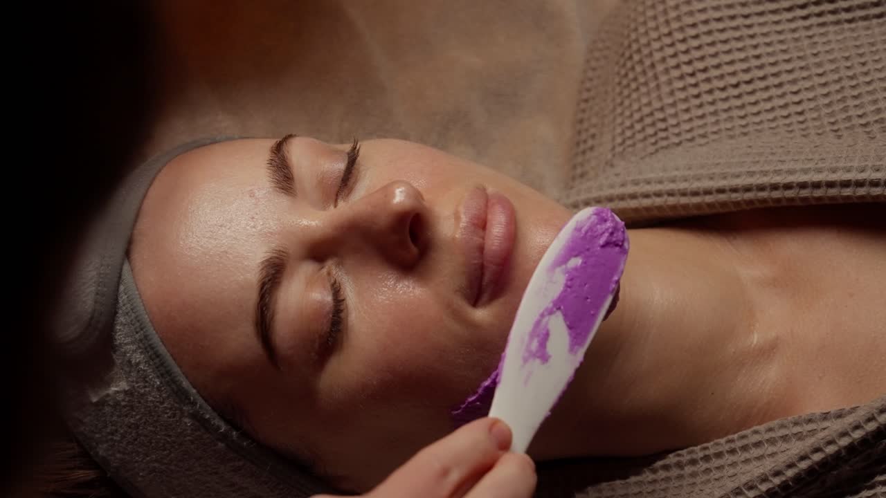 Gros plan d'une femme recevant un masque facial violet