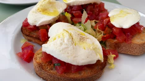 Klassisches-Traditionelles-Italienisches-Bruschetta-Brot-Mit-Tomaten,-Mozzarella-Käse-Und-Olivenöl,-Leckeres-Essen,-4K-Aufnahme