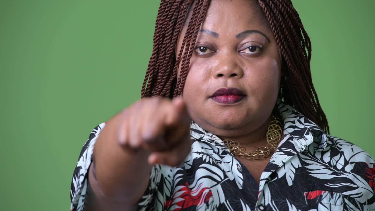 mujer africana hermosa con sobrepeso contra un fondo verde