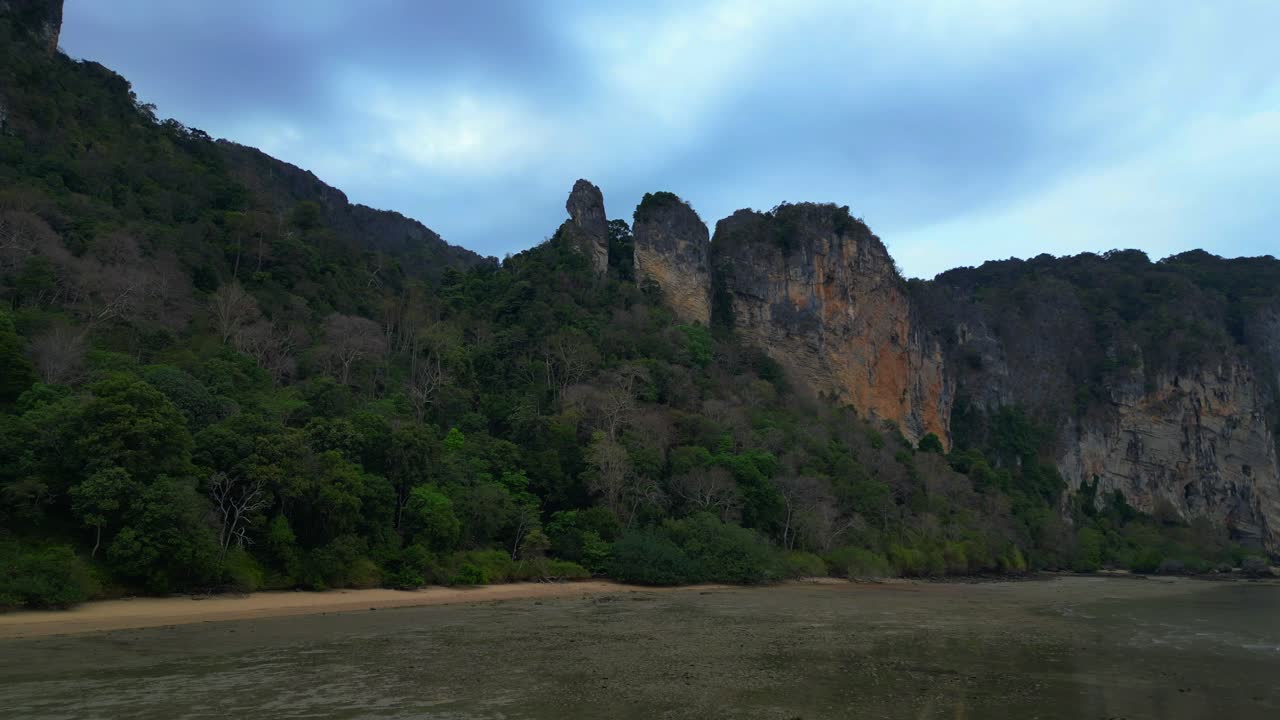 Limestone karst formations at low tide, Railay Beach Krabi, Thailand. Unbelievable aerial view flight fly reverse drone