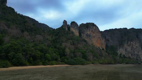 Limestone karst formations at low tide, Railay Beach Krabi, Thailand. Unbelievable aerial view flight fly reverse drone