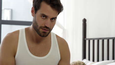 boyfriend writing a message on his smartphone while her girlfriend is sleeping