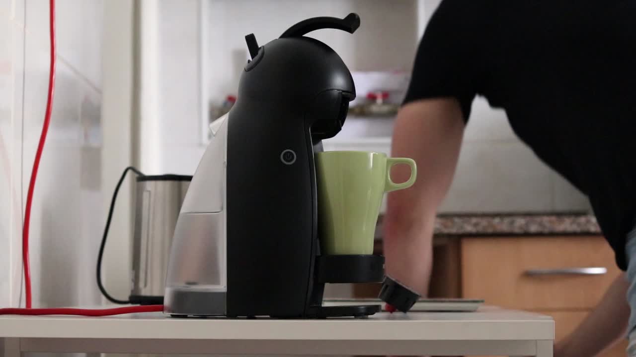 Man making coffee with a coffee machine, side view.