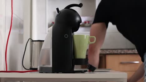 man making coffee with a coffee machine, side view.