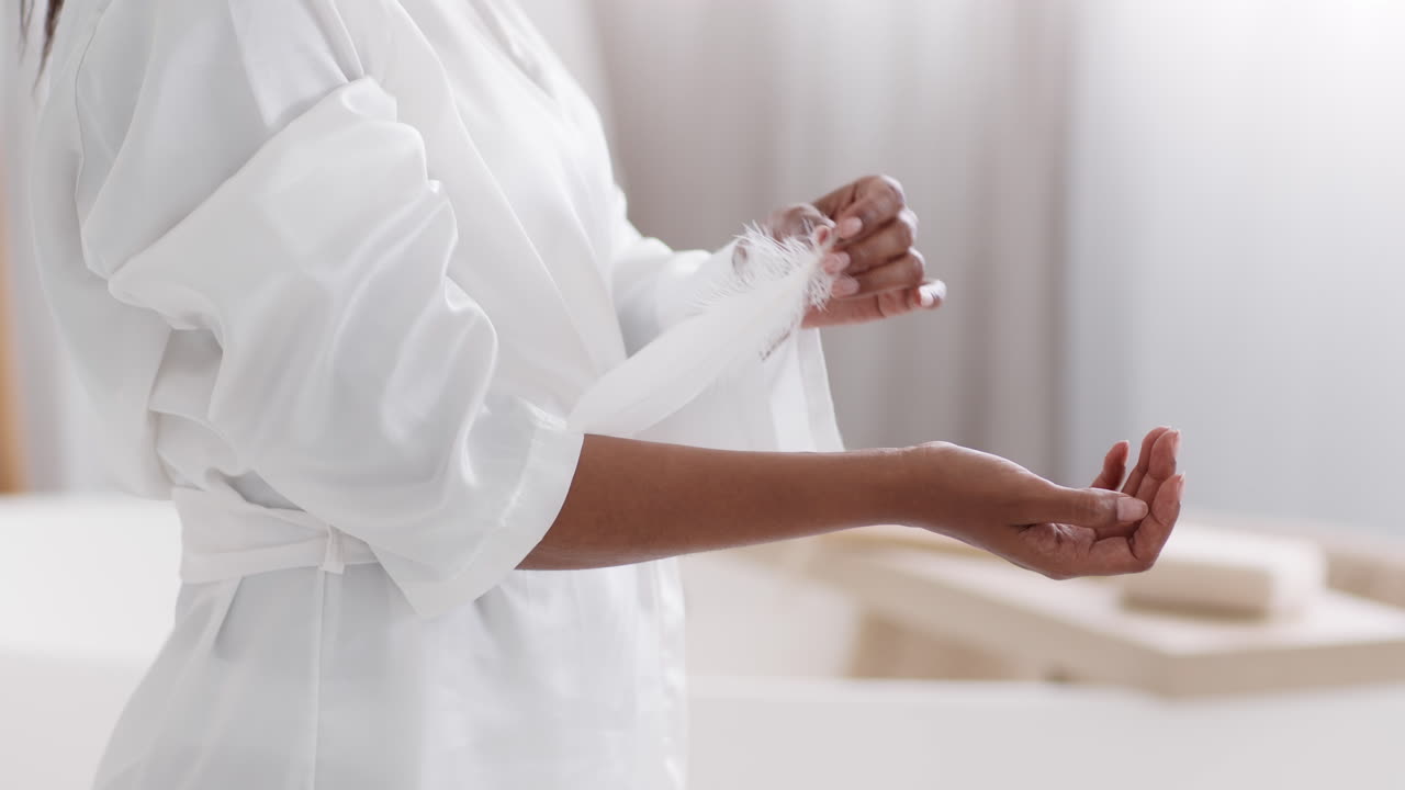 Mujer sosteniendo una pluma con una túnica blanca