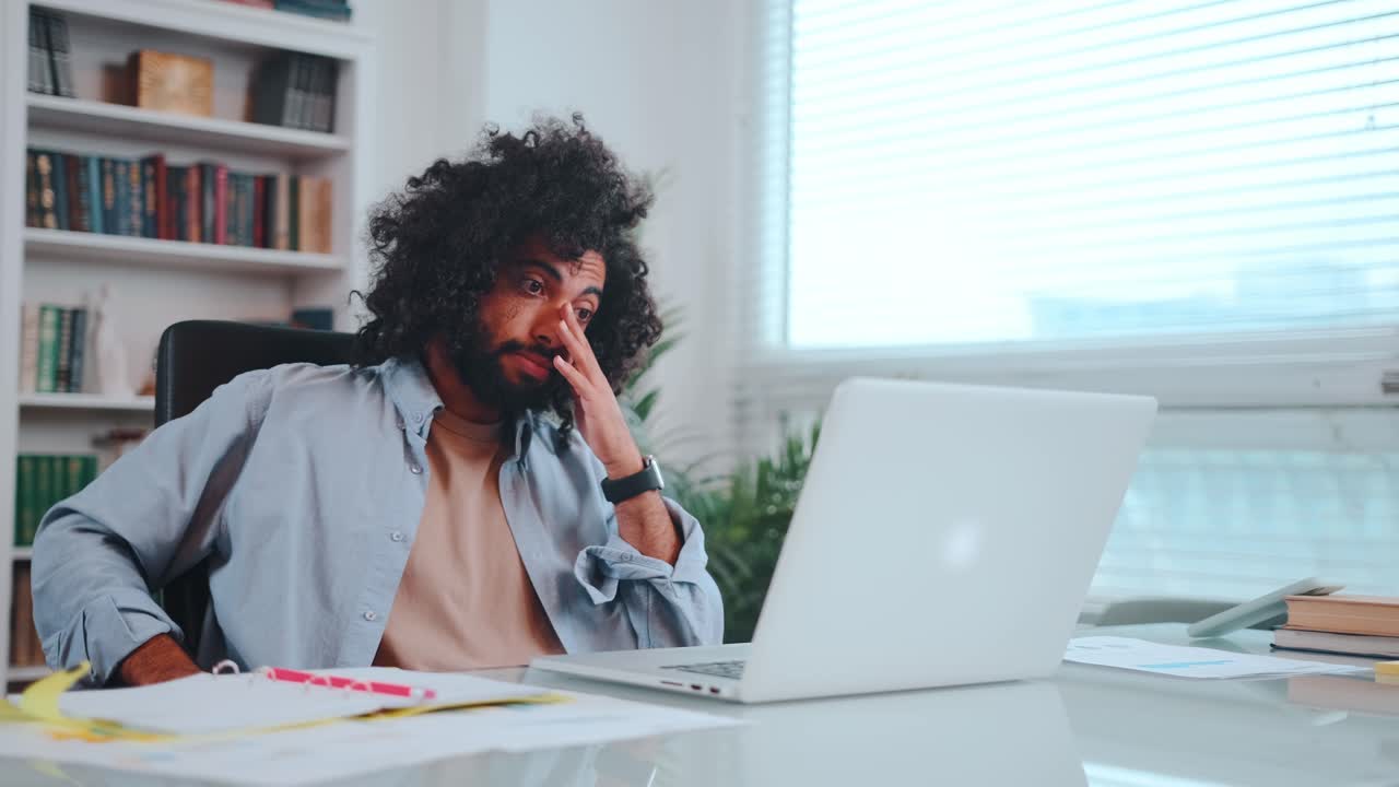 Young arabian american man programmer typing on keyboard getting frustrated