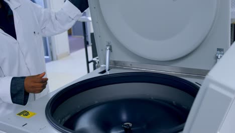 laboratory technician placing blood bags in machine 4k