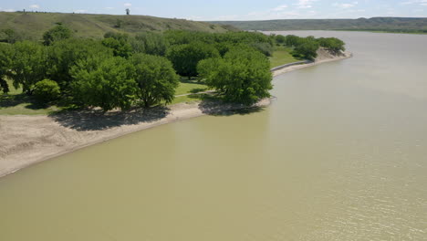 aguas tranquilas con un idílico paisaje de laderas verdes durante el otoño en el lago diefenbaker, saskatchewan, canadá