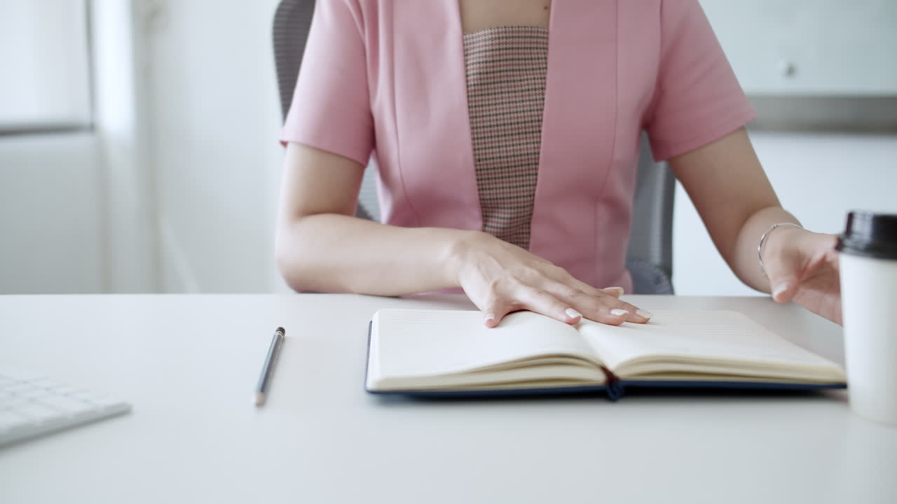 A focused individual enjoys a coffee break while jotting notes in a notebook emphasizing productivity and work-life balance.