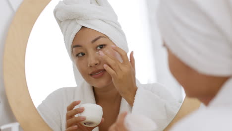 mujer aplicando crema ocular