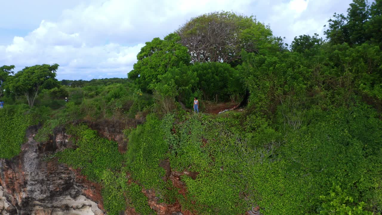 vuela con una mujer sobre los escarpados acantilados de piedra caliza de uluwatu en bali, indonesia