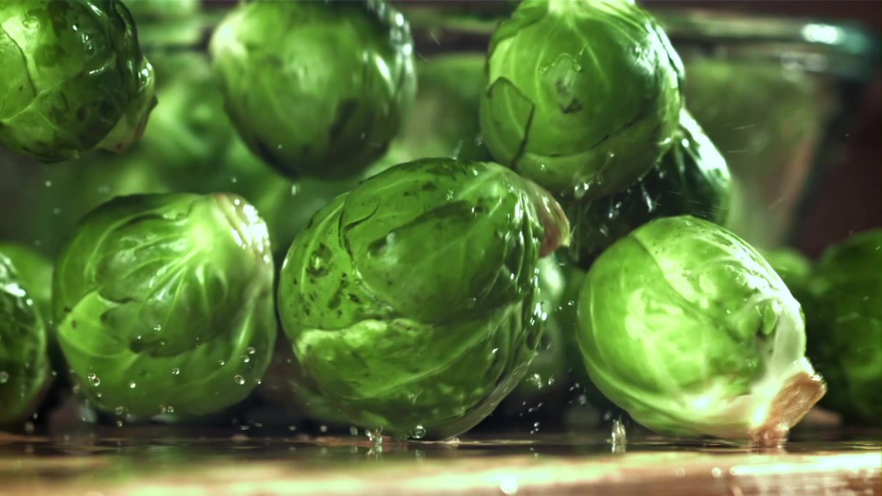 Frischer grüner Rosenkohl fällt und spritzt mit Wasser
